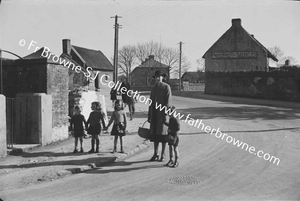 WOMAN BRINGING CHILDREN TO SCHOOL